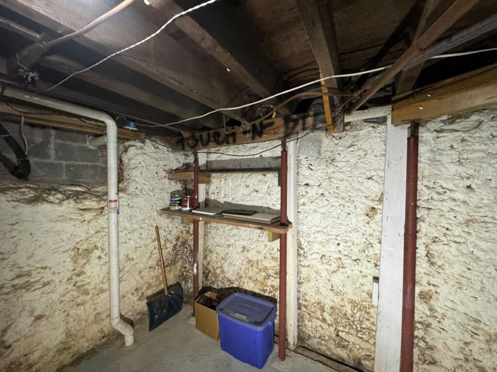 Basement showing water and fire damage with temporary insufficient framing supports.